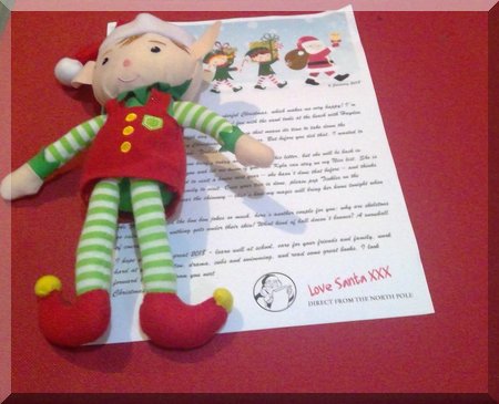 Elf lying on a letter from Santa