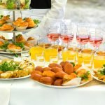 Plates of pies, eclairs and drinks on a Christmas banquet table