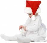 Little girl in a Santa hat opening a Christmas gift