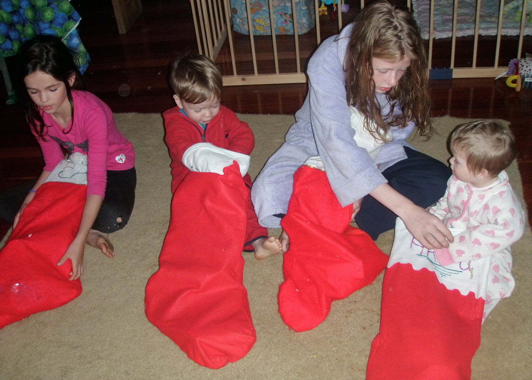Four children opening Santa stockings on Christmas morning