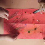 children decorating a red paper lantern