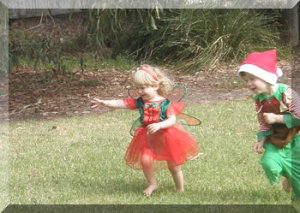 Children dressed in CHristmas costumes running in a parkk