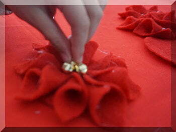 | love santa small hand adding bells to a felt flower