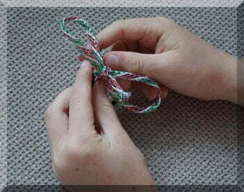 | love santa child's hands with a finished Christmas ribbon bow