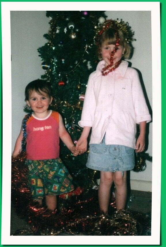 two young girls in front of a Christmas tree