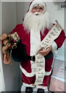 Tall Santa ornament standing and holding a long list of names