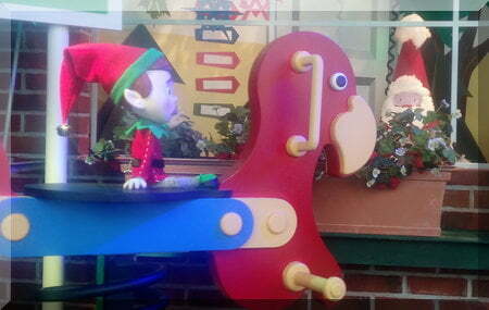 Elf sitting on a colourful seesaw