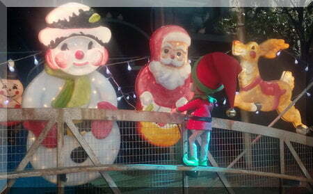 elf looking at Santa, a snowman and reindeer decroations