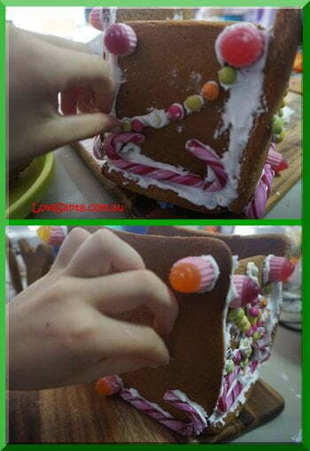 | love santa CHild's hand attaching lollies to a gingerbread sleigh