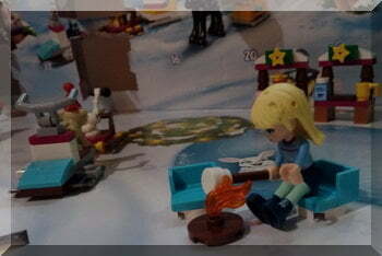 Lego girl sitting at a campfire toasting marshmallows