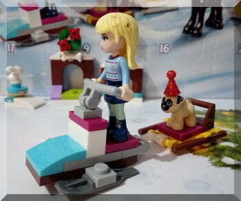 Lego girl on snowmobile pulling a dog sled