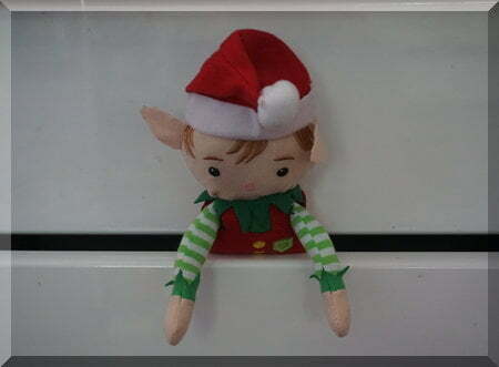 Tinkles the Elf peaking out of a white kitchen drawer