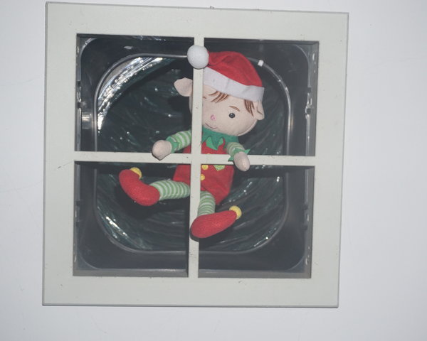 Tinkles the Christmas elf hanging in a ceiling vent