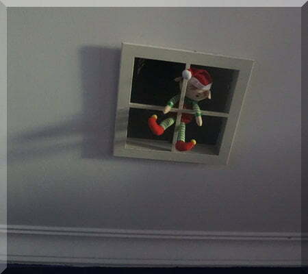 Tinkles the Christmas elf hanging in a ceiling vent
