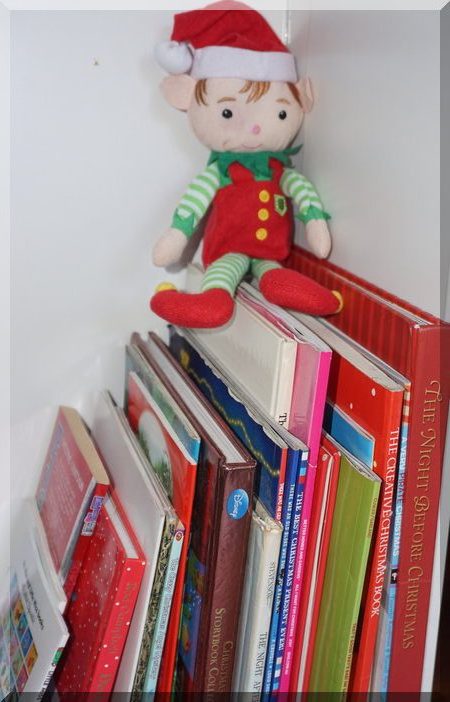 Tinkles the elf sitting on some Christmas books