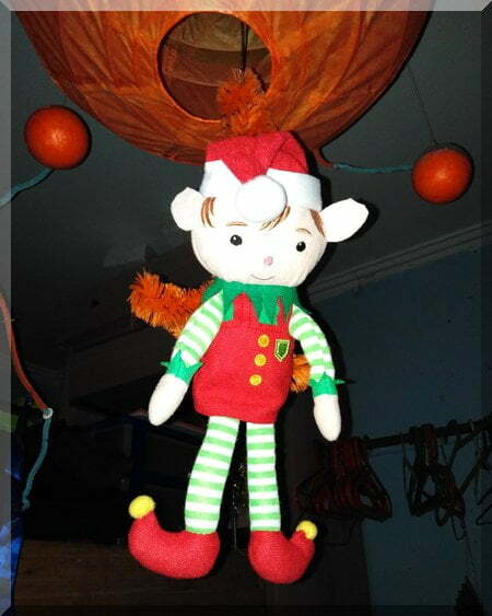 Tinkles the elf hanging from an orange ocotpod light fitting