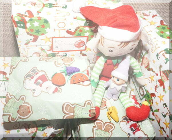 Christmas elf with baby sitting on Christmas presents