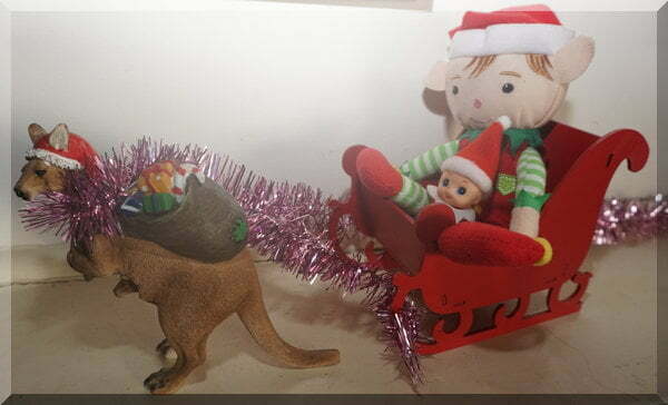 Christmas elf and baby elf is Santa;s sleigh pulled by a boomer