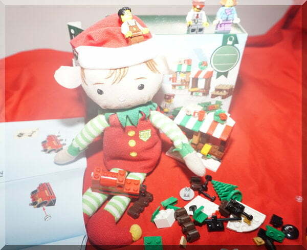 Tinkles building the Lego Christmas train, watched by three mini figs