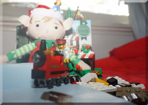 Tinkles the Christmas elf building a Lego train