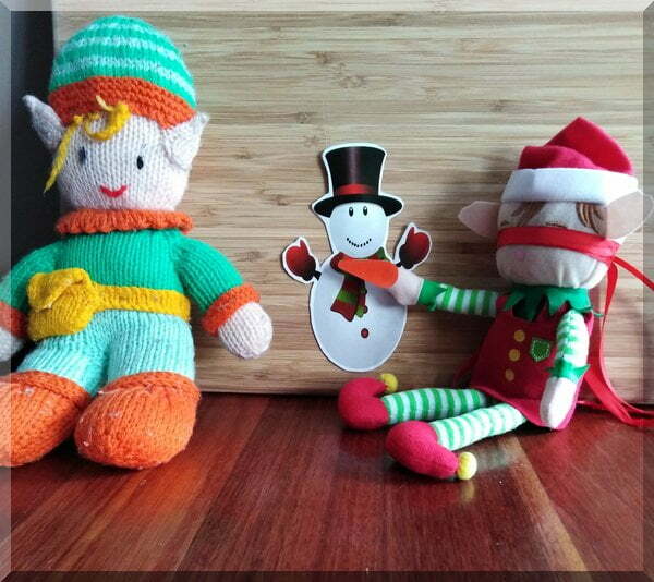 Christmas elf and tooth elf playing pin the nose on the snowman