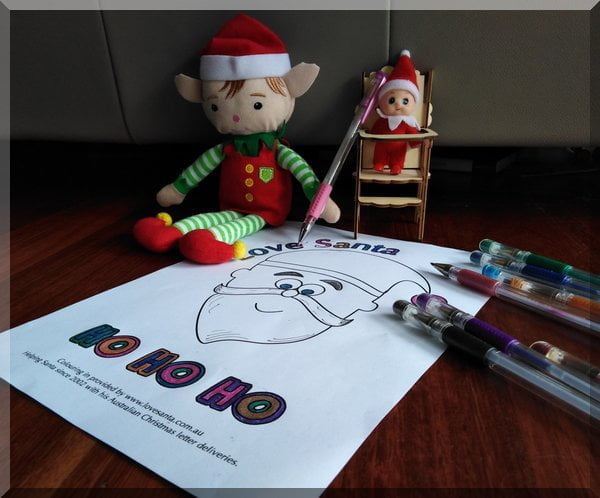 Christmas elf colouring in a Love Santa picture