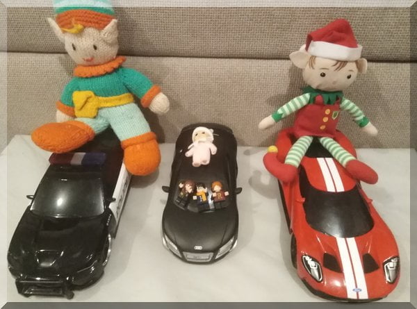 three elves seated on remote control cars
