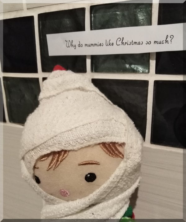 Tinkles the Christmas Elf wrapped as a mummy,asking why do mummies love Christmas