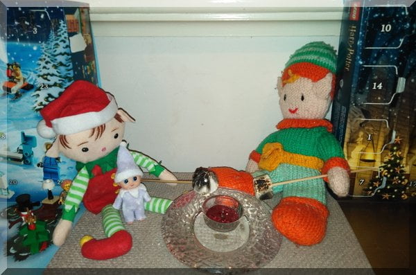 Christmas and Tooth Elves toasting marshmallow on a Christmas candle