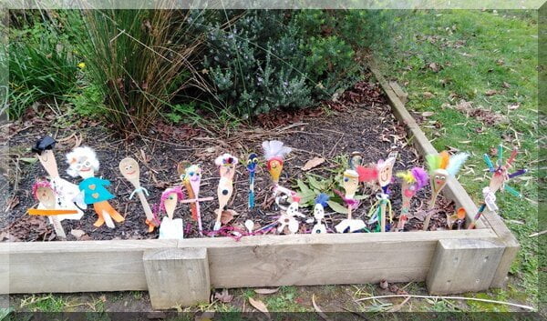Set of colourful spoon people in a kinder garden bed