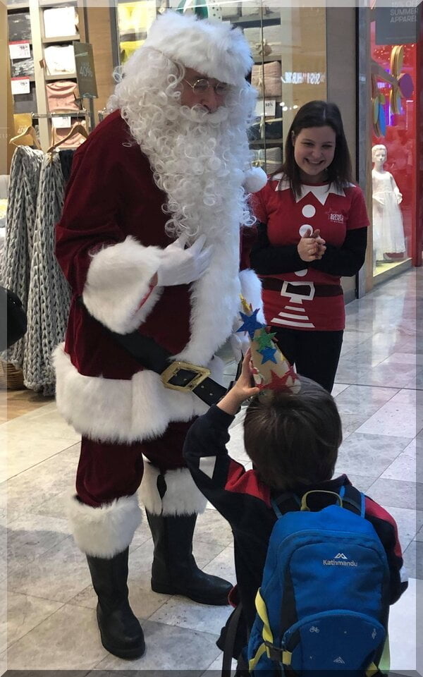 Santa and elf talking to a child in a shopping centre