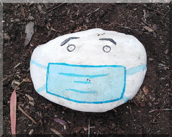 A white rock with eyes and a blue mask painted on