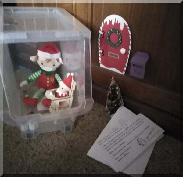 two Christmas elves in self-isolation beside their North Pole door