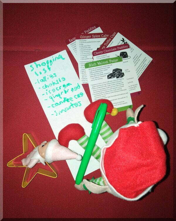 Christmas elf holding a green texta and writing a shopping list of sugary treats!