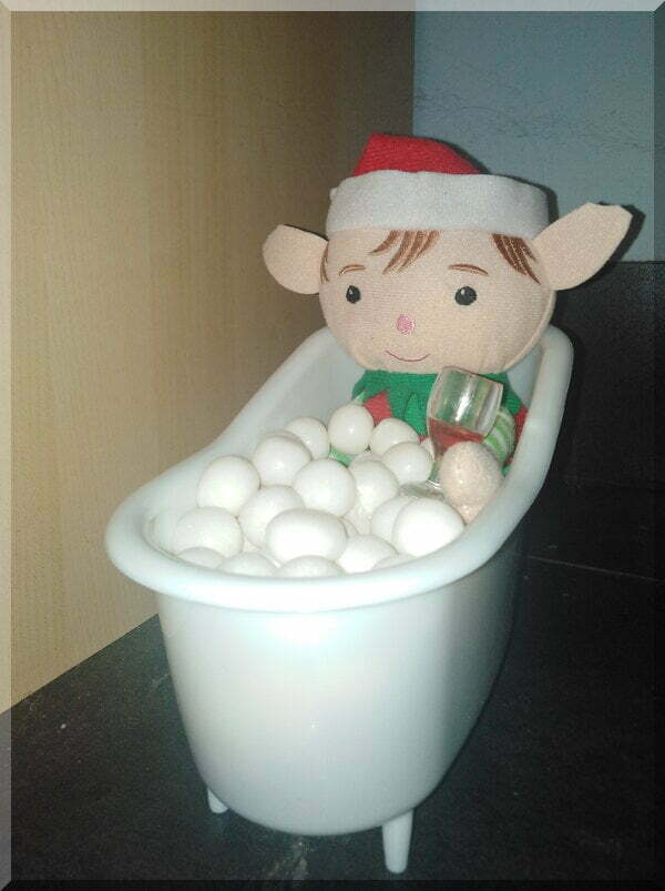 Tinkles_bath_wine600 | love santa Christmas elf sitting in a bath with white balls as bubbles