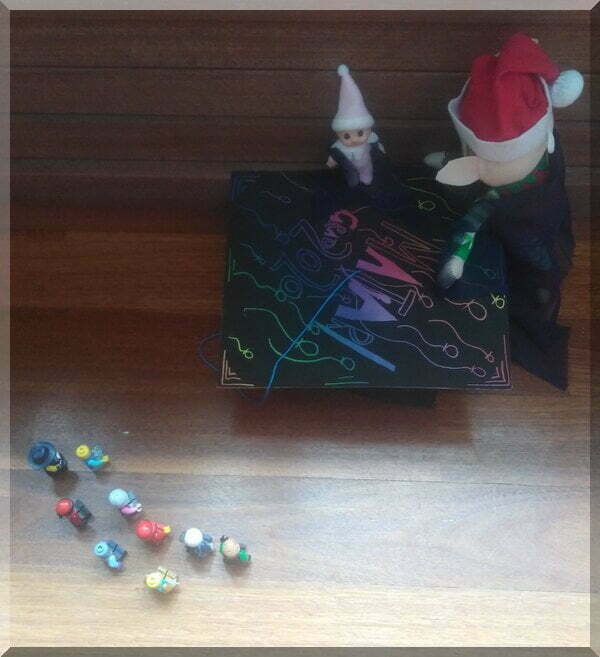 Christmas elves in long gowns, graduating in front of a Lego crowd