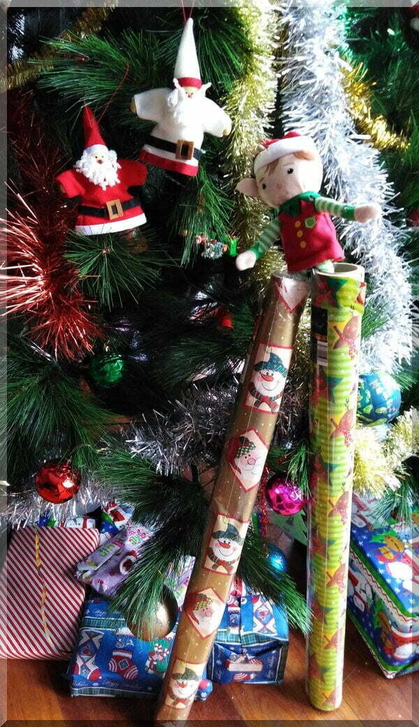 Christmas elf on stilts (actually Christmas paper rolls)