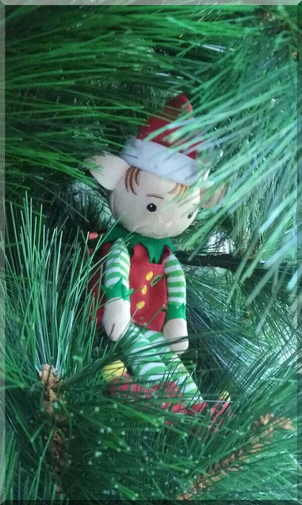 Tinkles the Christmas elf hiding in a Christmas tree without lights