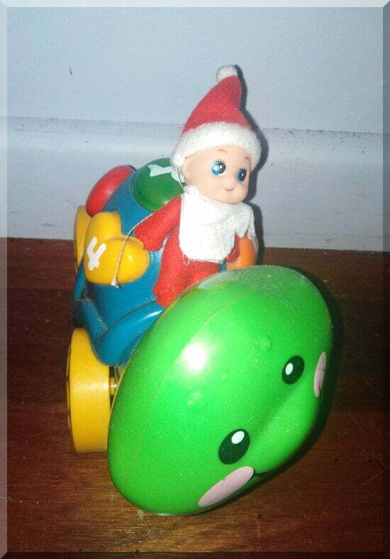 Ginger-ride-turtle_550 | love santa Baby CHristmas elf sitting on a green and blue toy turtle