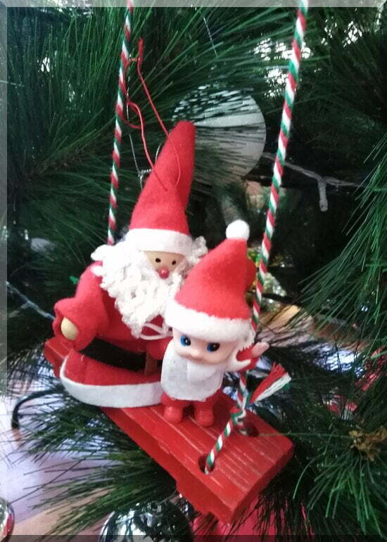 Ginger_santa_swing_550 | love santa Baby Christmas elf sitting with Santa on a red wooden swing hanging in a Christmas tree