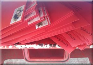 Red-envelopes-into-post-box-650 | love santa A pile of red envelopes being place in the slot of a red Australia Post letterbox