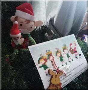 Christmas elf and baby with a letter from Santa on a Christmas tree