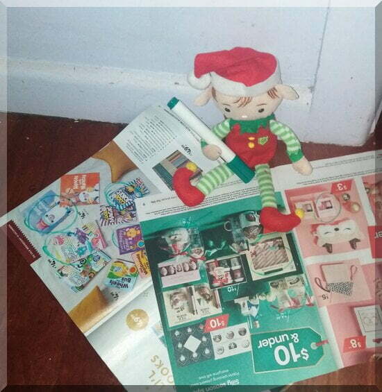 Christmas elf sitting with a green texta and some junk mail