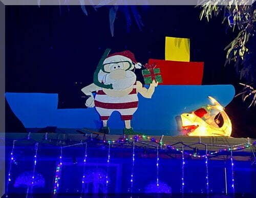 Santa in bathers and snorkle in front of a boat