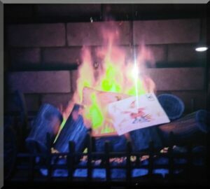 Movie shot of two envelopes burning in a fire place