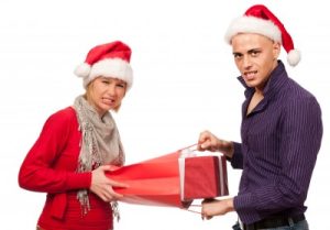 Playing dirty Santa is like fighting over presents! Photo of a man and woman tugging on a Christmas gift