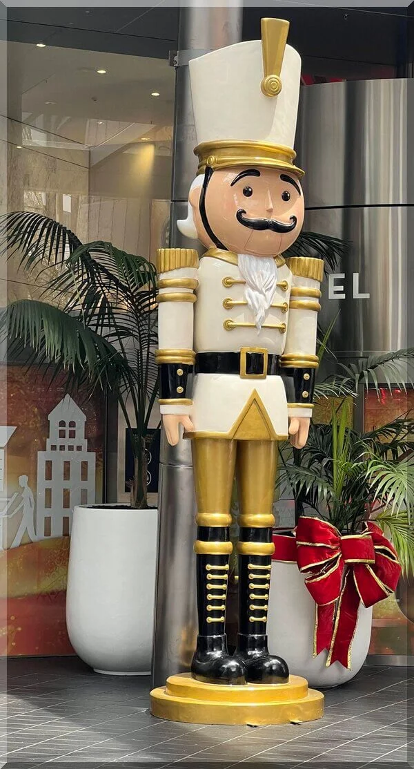 Gold_nutcracker_hotel_auckland_nov2023-600 | love santa A tall golden nutcracker standing beside palm trees as art of Christmas in Auckland